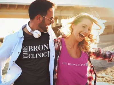 young couple walking wearing the bronx clinic shirt